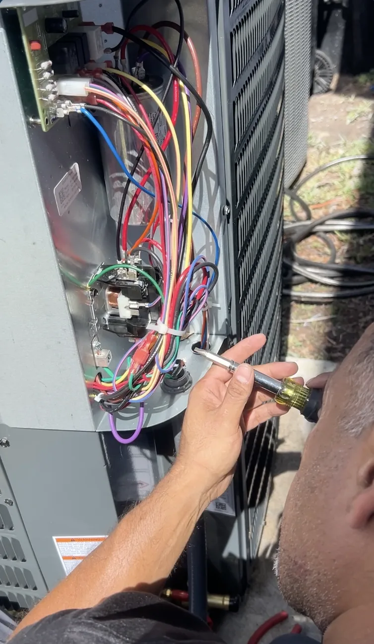 Smart Home Air & Heat technician repairing AC condenser unit wiring in Orlando